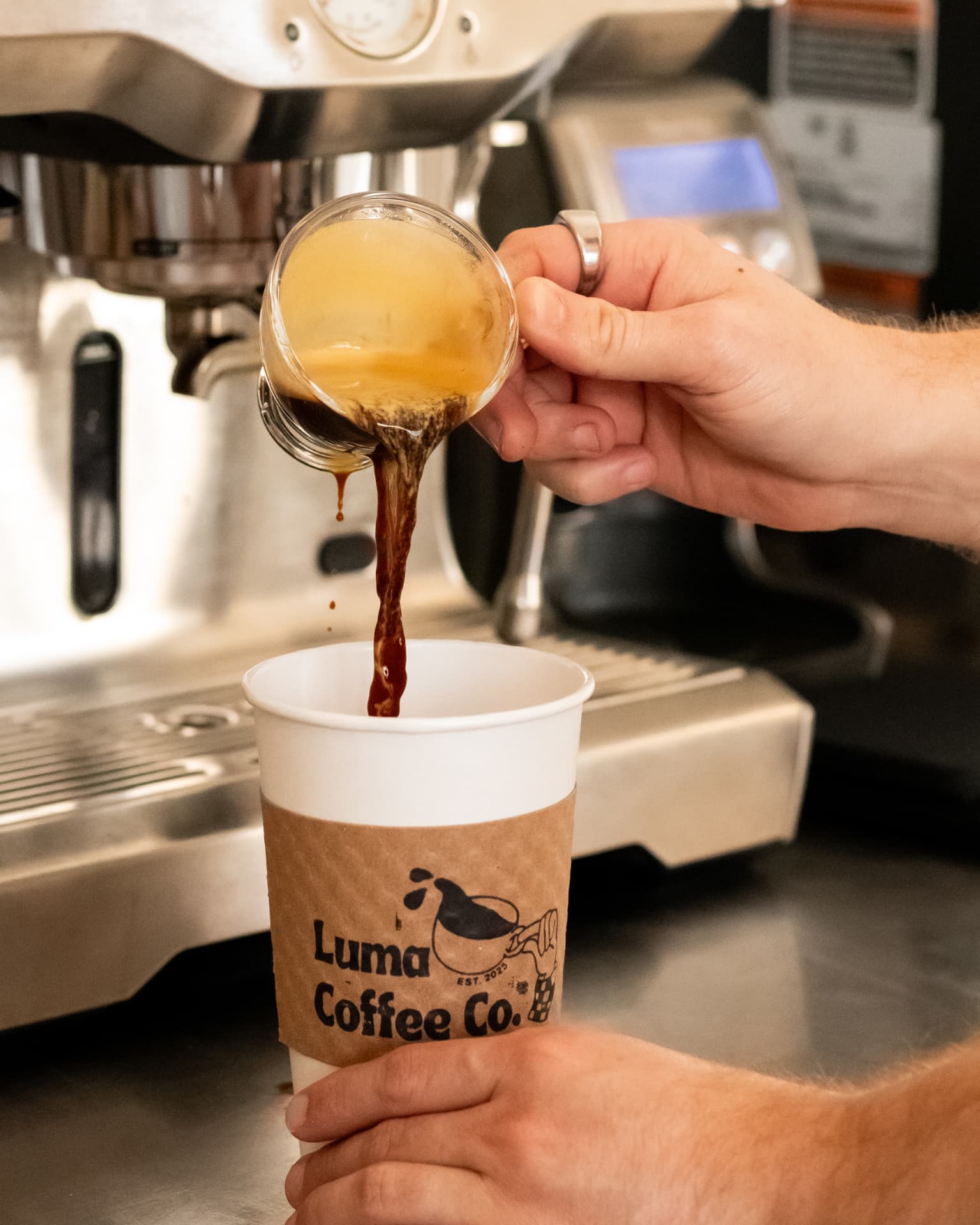 A fresh espresso shot being poured into a Luma Coffee Co. cup