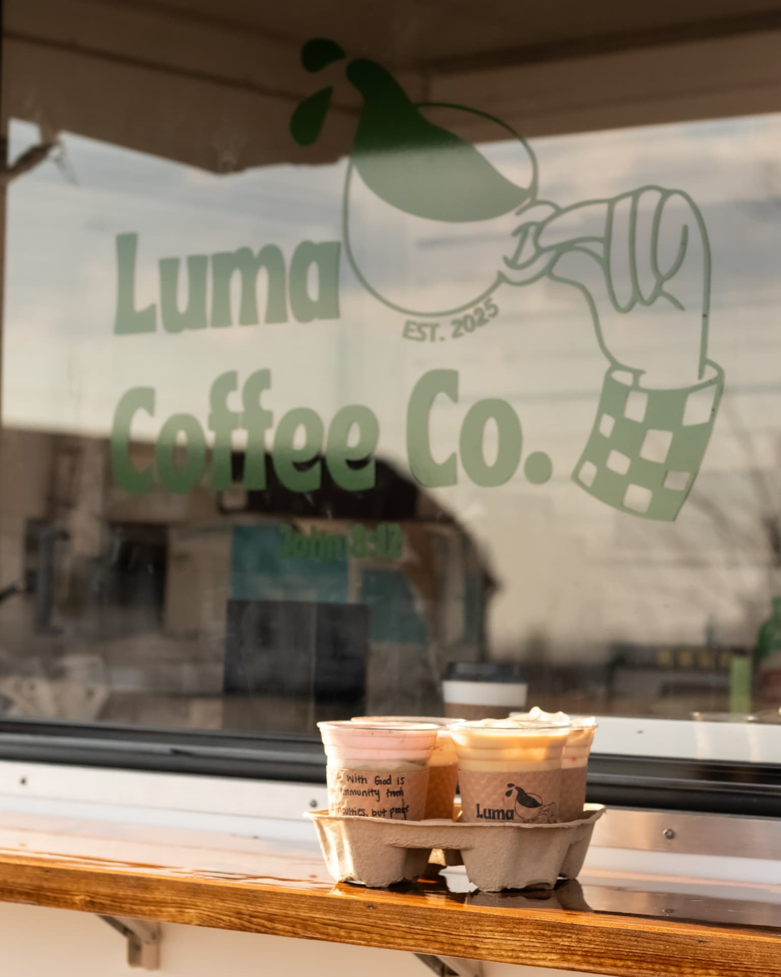 Drinks in a carrier on the Luma Coffee Co. cart window ledge