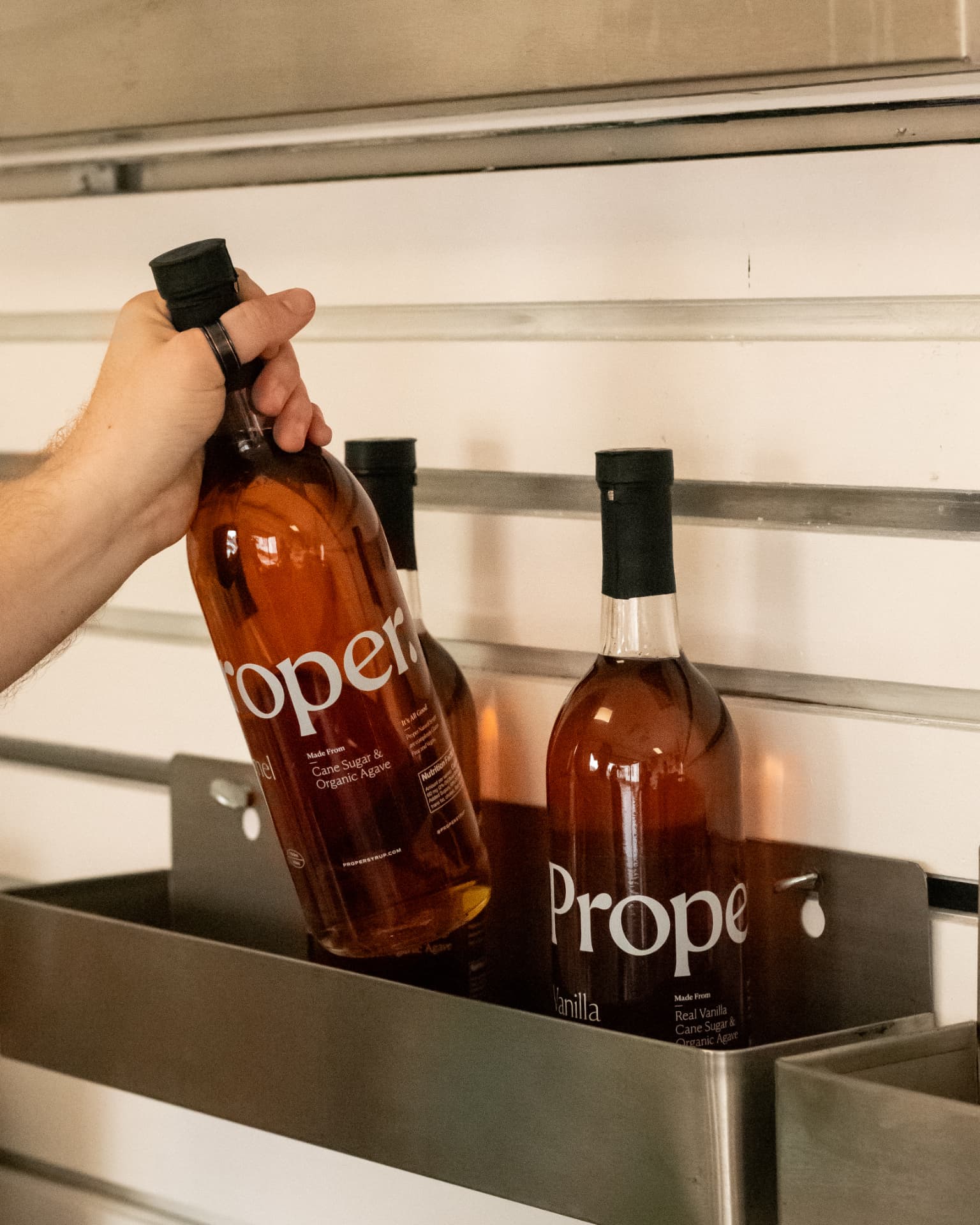 Bottles of Proper syrup in the Luma Coffee Co. cart