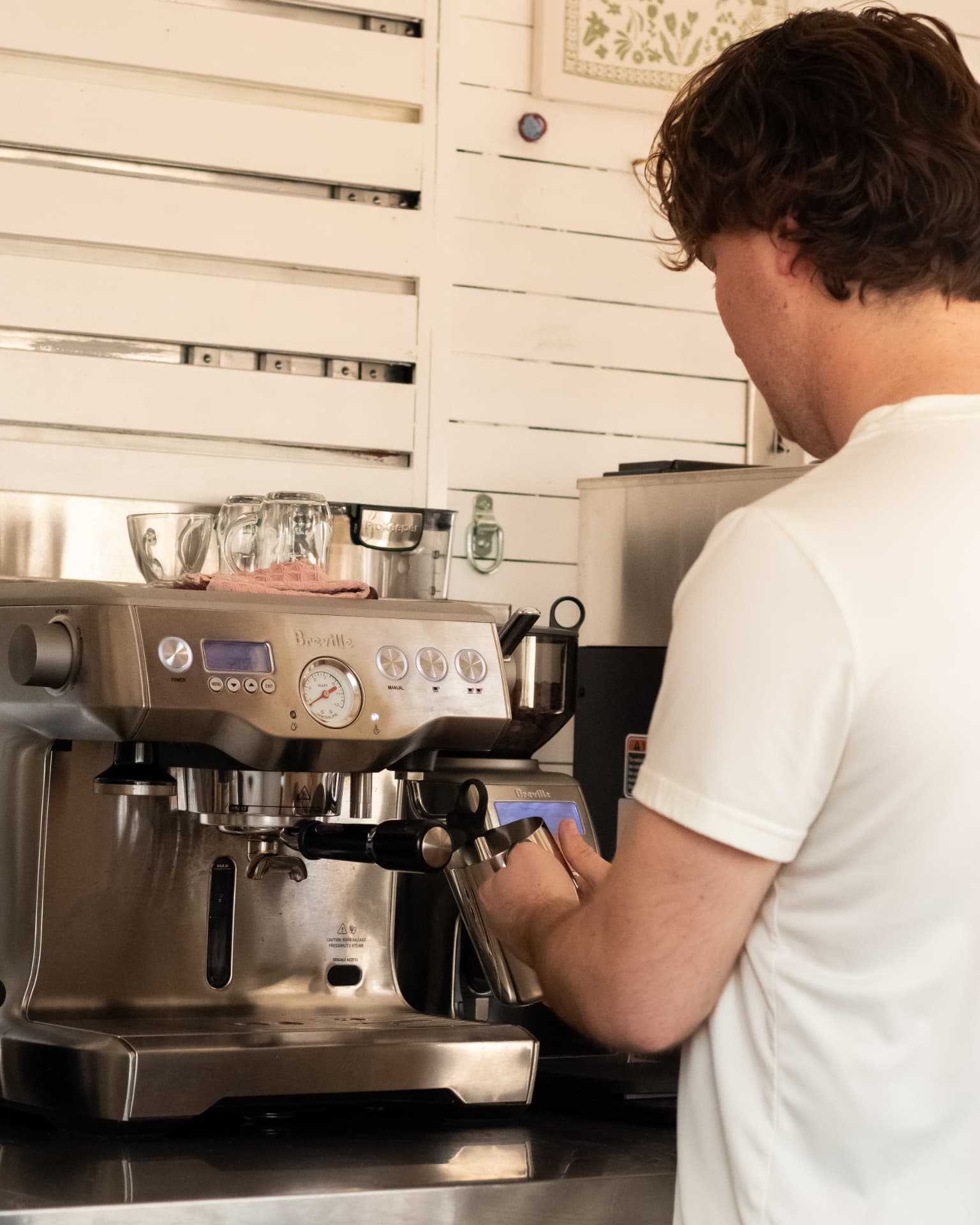A Luma Coffee Co. barista steaming milk at the espresso machine